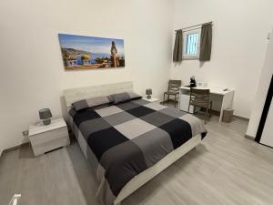 a bedroom with a black and white bed and a table at DM Rooms in Catania +7 photos