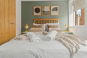 a bedroom with a large white bed with two lamps at Pear Tree - Stylish City Centre Apartment in Worcester