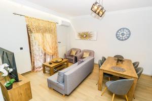 a living room with a couch and a table at Four lakes luxury suites in Amintaio