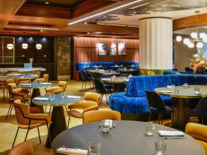 a restaurant with tables and blue couches and chairs at Mercure Lyon Centre Saxe Lafayette in Lyon