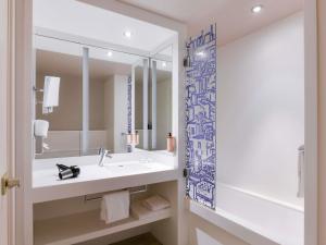 a bathroom with a sink and a mirror at Mercure Lyon Centre Saxe Lafayette in Lyon +98 photos