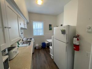 a kitchen with a white refrigerator and a table at Wolfville Veranda Suite 1 Downtown Vibrancy in Wolfville