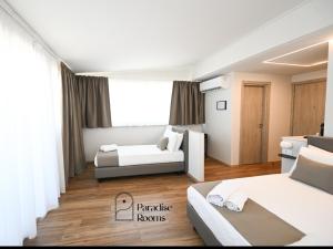una habitación de hotel con dos camas y un sofá en Hotel Paradise Rooms, en Bitritto
