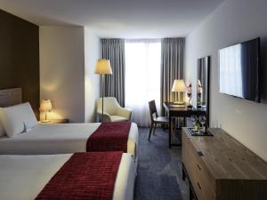 a hotel room with two beds and a desk at Mercure Montevideo Punta Carretas in Montevideo +58 photos