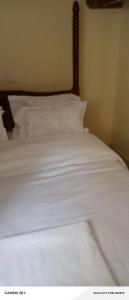a white bed with white sheets and pillows at Langata bnb in Nairobi