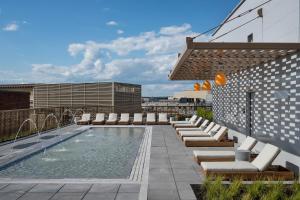 a pool on the roof of a building with lounge chairs at ROOST White House in Washington