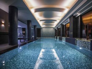a swimming pool in a hotel with ailed floor at Quay West Suites Melbourne in Melbourne