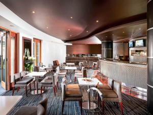 a restaurant with tables and chairs and a bar at Quay West Suites Melbourne in Melbourne