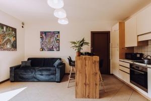 a kitchen and a living room with a couch at Prosecco Hills Escape Relax tra le colline Unesco in Campea