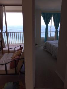 Un dormitorio con una cama y un balcón con vista al mar. en Ocean View Apartment in Family Complex, en Puchuncaví 1 foto más