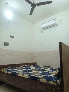 a bedroom with a bed and a ceiling fan at Shri Ram Janam Homestay 300 Meter from Ram Mandir in Ayodhya