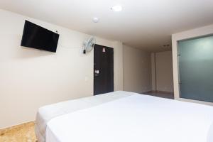 a bedroom with a bed and a flat screen tv at Hotel Bossanova in Rionegro +7 photos