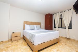 a bedroom with a large bed and a window at Hotel Bossanova in Rionegro