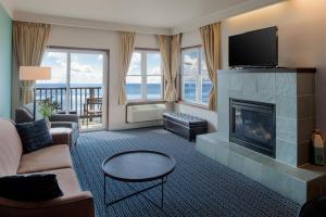 a living room with a fireplace and a television at Inn at Nye Beach in Newport