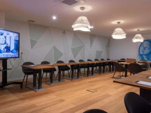 d'une salle de conférence avec des tables et des chaises et une télévision à écran plat. dans l'établissement Hotel & Spa Kasano Calvi - Handwritten Collection, à Calvi 145 autres photos