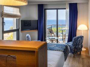une chambre d'hôtel avec un lit et une vue sur l'océan dans l'établissement Hotel & Spa Kasano Calvi - Handwritten Collection, à Calvi