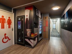 un corridoio con un distributore automatico di bevande e un cartello per disabili di ibis budget Rennes Chantepie - Hôtel rénové a Chantepie