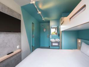 una camera da letto con un letto grande e un lavandino di ibis budget Rennes Chantepie - Hôtel rénové a Chantepie Altre 30 foto