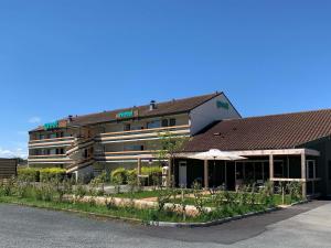 een hotelgebouw met een paraplu ervoor bij greet Hotel Belleville en Beaujolais A6 in Belleville-sur-Saône