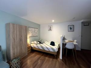 a bedroom with a bed and a desk and a table at Le Farconnet in Tournon-sur-Rhône