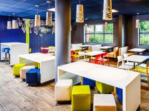 a restaurant with brightly colored tables and chairs at ibis budget Manchester Salford Quays in Manchester
