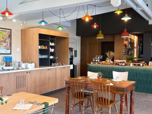un restaurante con una mesa de madera y un bar en Greet Hôtel Dijon Sud Longvic, en Longvic