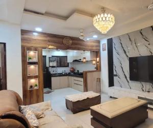 a living room with a couch and a kitchen at Avenaa Villa Rahul Residency Ganeshpeth Nagpur in Nagpur +19 photos