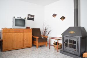 a living room with a wood stove and a tv at Chuca House in Requiás