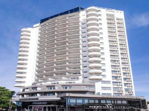 a large white skyscraper with a building at Mercure Rosario in Rosario