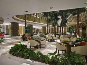 a restaurant with tables and chairs and palm trees at Swissôtel Clark Philippines in Clark