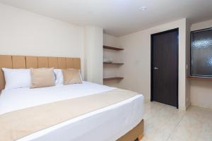 a bedroom with a large white bed and a window at Hotel Bossanova in Rionegro