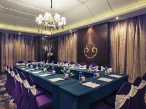 a long table in a room with purple chairs and a chandelier at Mercure Xiamen Exhibition Centre in Xiamen +71 photos