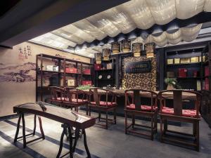a restaurant with a table and chairs in a room at Mercure Xiamen Exhibition Centre in Xiamen