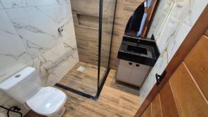 a bathroom with a toilet and a glass shower at Vila Encantada – Ponta de Pedras in Ilha Arapiuns