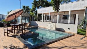 a pool with a table and chairs and an umbrella at Vila Encantada – Ponta de Pedras in Ilha Arapiuns +8 photos
