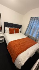 a bedroom with a large bed with an orange blanket at Saint Paul 03 in Bristol