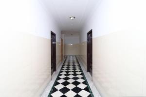 a hallway with a checkered floor and two doors at Super Hotel O Mehtab Regency in Rewāri