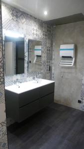 a bathroom with a sink and a mirror at Gîte du Tronquoy in Aix-en-Ergny