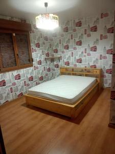 a bedroom with a bed in a room with posters on the wall at Gîte du Tronquoy in Aix-en-Ergny