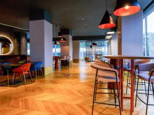 una habitación con mesas y sillas en un edificio en Mercure Galati Centrum, en Galaţi