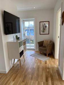 a living room with a television and a desk and a chair at F27-1 3 people, 3 bedrooms, fully furnished in Aalborg