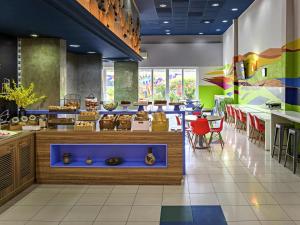 a restaurant with a counter and tables and chairs at ibis budget Belem in Belém