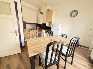a kitchen with a wooden dining table and chairs at Boulevard 4 personnes Un Séjour à Part in Longeville-lès-Metz