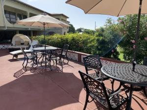 a patio with tables and chairs and an umbrella at Cortsland Hotel in Saint Johnʼs