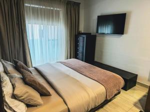a bedroom with a bed and a flat screen tv at Modern 4-Bedroom Villa with Private Pool & 2 Baths in Taʼ Ċantar