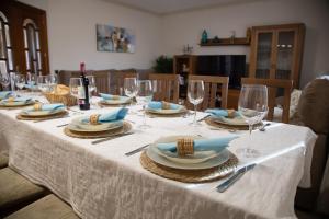 a table with plates and wine glasses on it at Casa Rural La Libélula Azul in Polán