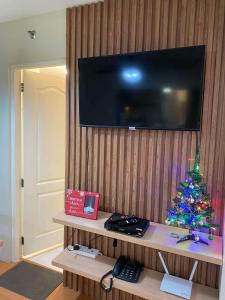 a christmas tree sitting on a shelf with a television at GusBek Condo Unit San Remo Oasis Cebu in Cebu City +5 photos