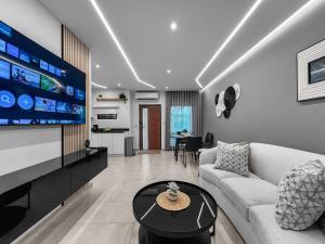 Una sala de estar con un sofá y un televisor. en Hyde Park 1 Your Comfy Apt With Parking in San Juan, en San Juan