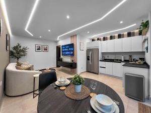 Una cocina y una sala de estar con una mesa. en Hyde Park 1 Your Comfy Apt With Parking in San Juan, en San Juan 8 fotos más