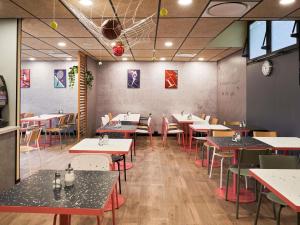 Un comedor con mesas y sillas en un restaurante. en ibis budget Saint-Maurice, en Saint-Maurice